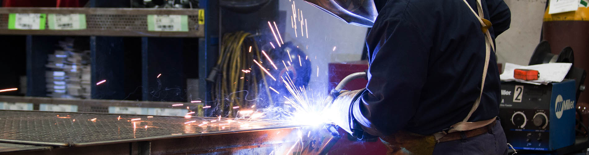 A welder using a welding tool, causing sparks to fly.