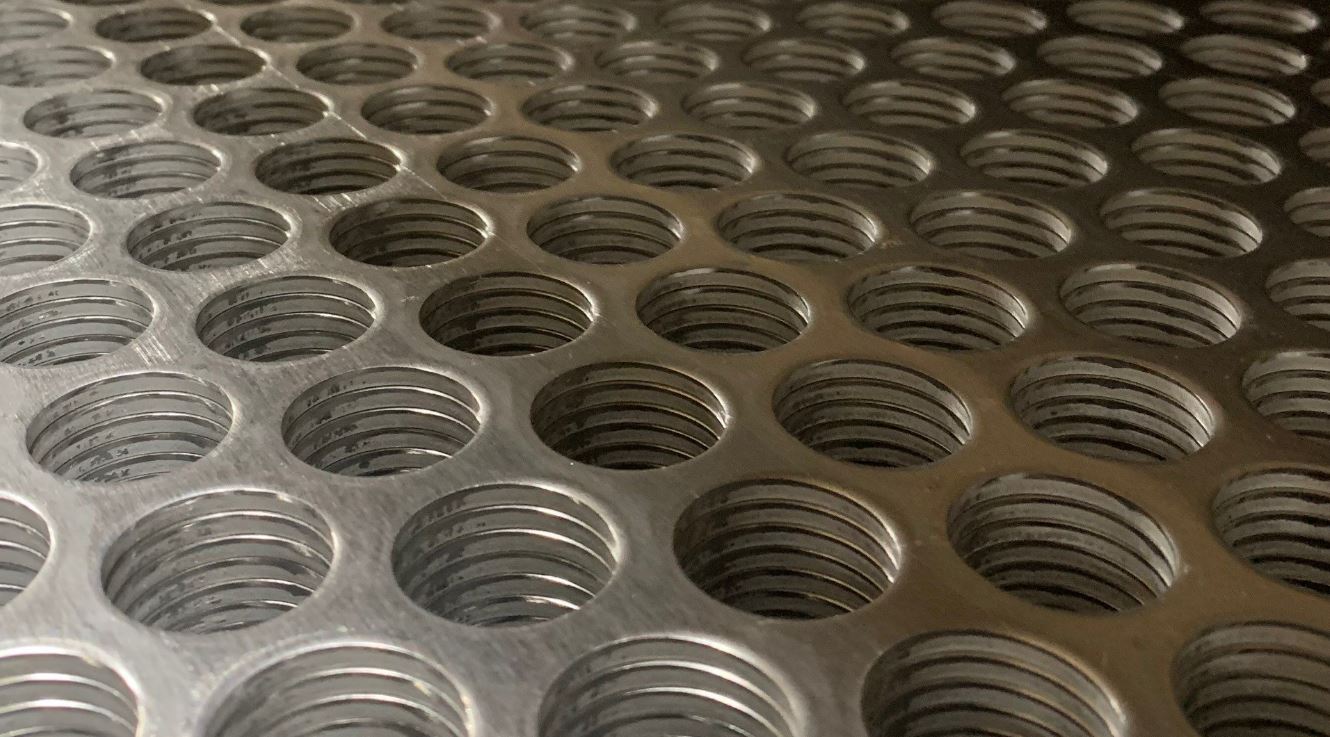A close-up photo of round hole perforated metal in aluminum.