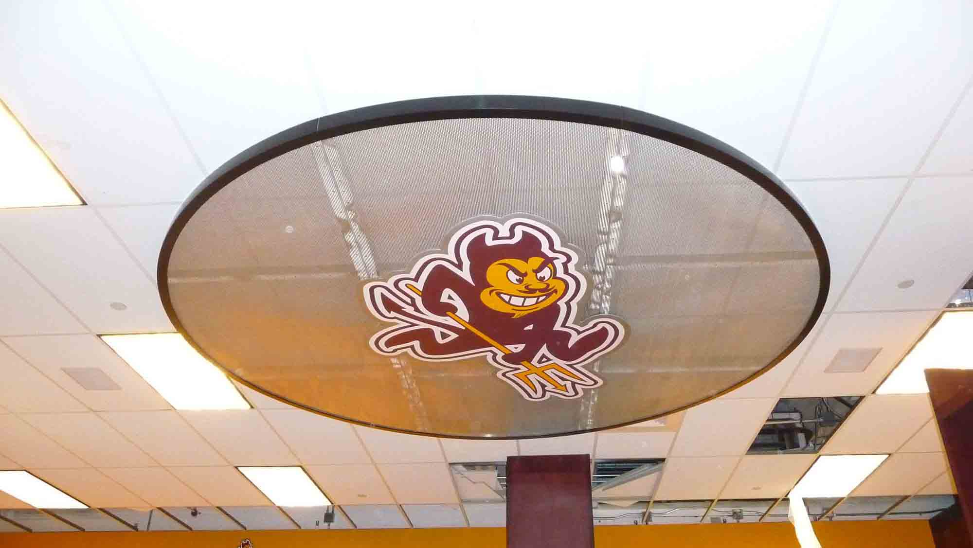 The ceiling inside the locker room at Arizona State University, focused on an ASU-themed circular disk, made out of Aluminum Perforated Metal.