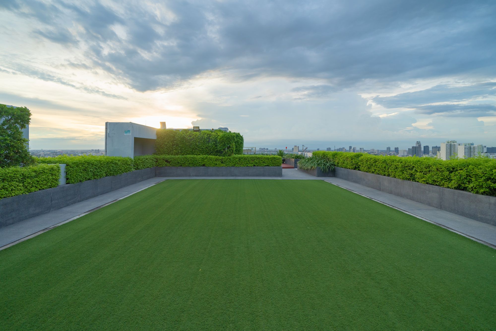 A picture of a turf field on a roof with the sky in the background.
