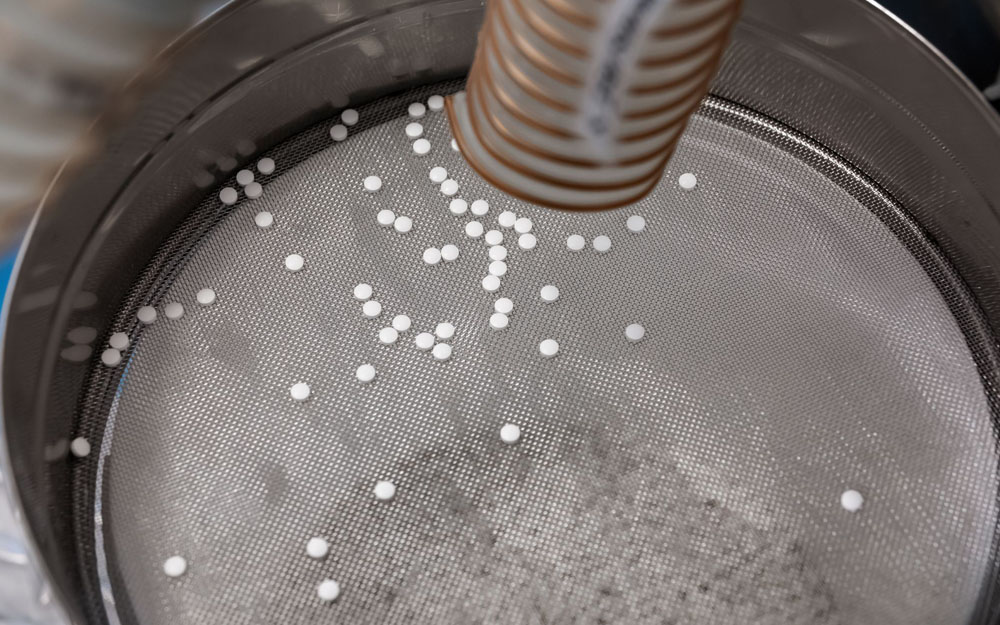 A sheet of Wire Cloth being used as a pill sifter in a pharmaceutical factory.