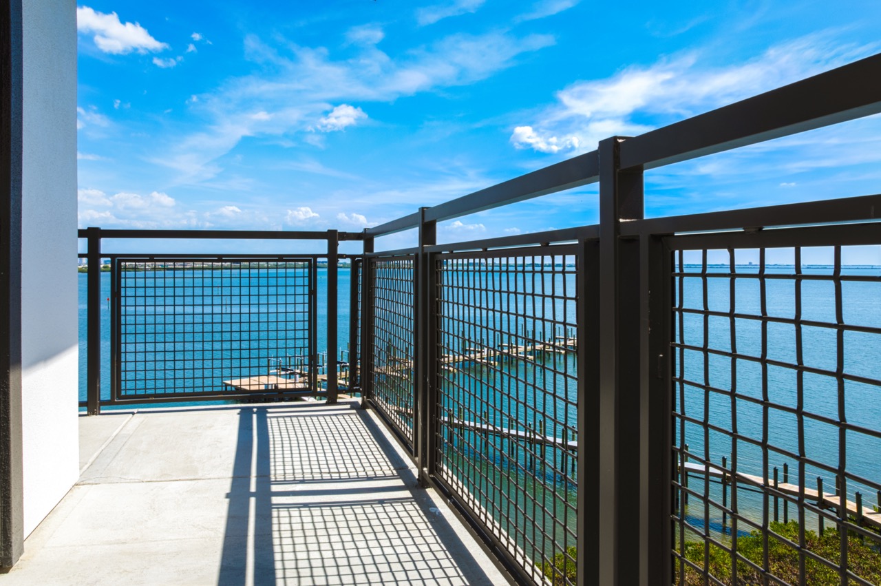 A photo of a balcony railing made up of Wire Mesh Infill Panels, overlooking the ocean.