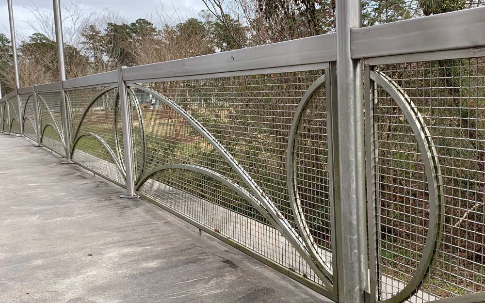A picture of Wire Mesh infill panels as a railing on the side of a bridge.