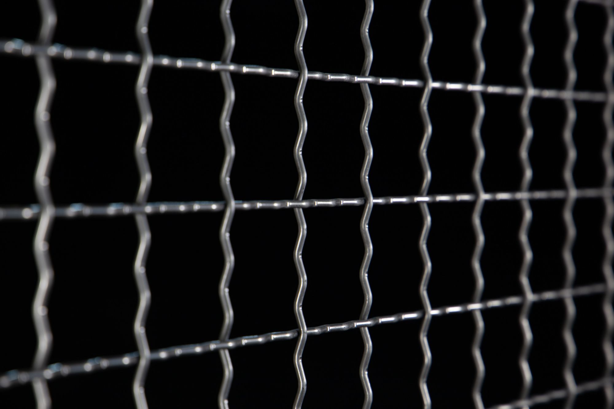 Close-up photo of Woven Wire Mesh on a black background.