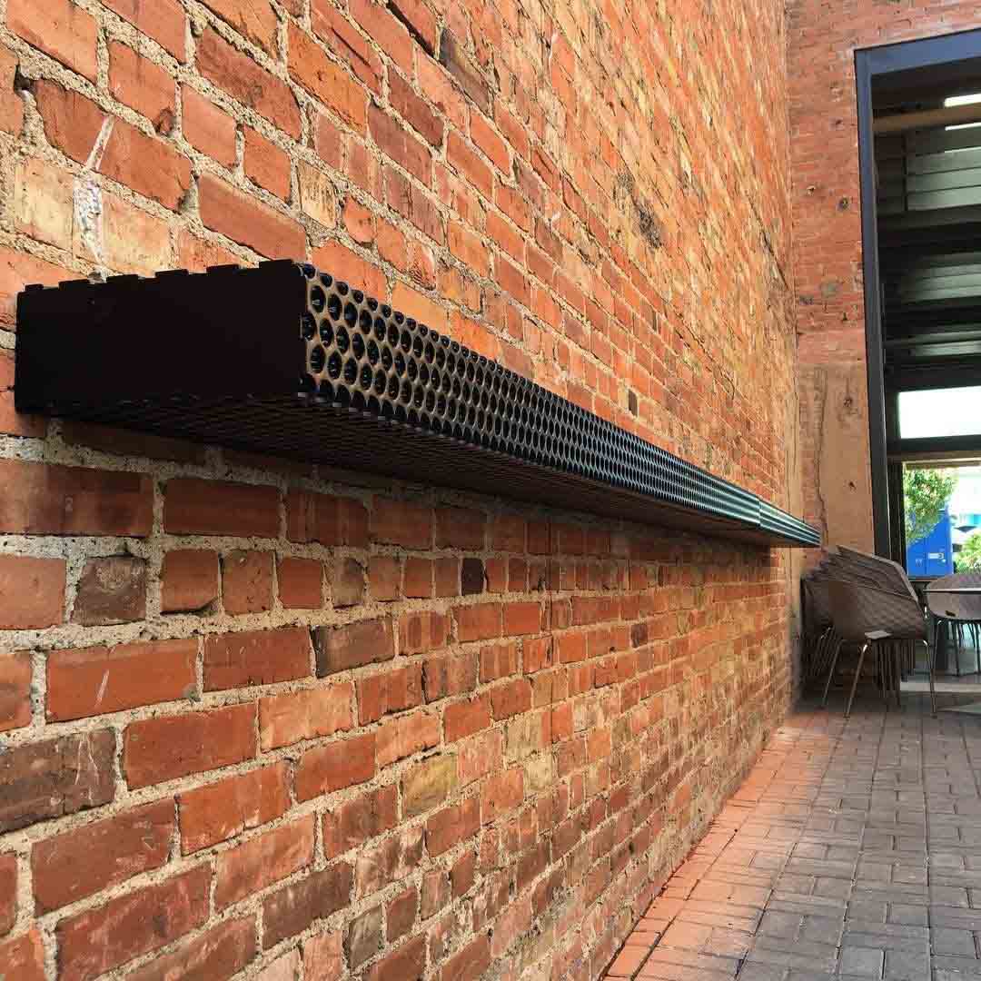 A Perforated Metal shelf on a brick wall at the Hide Bar.