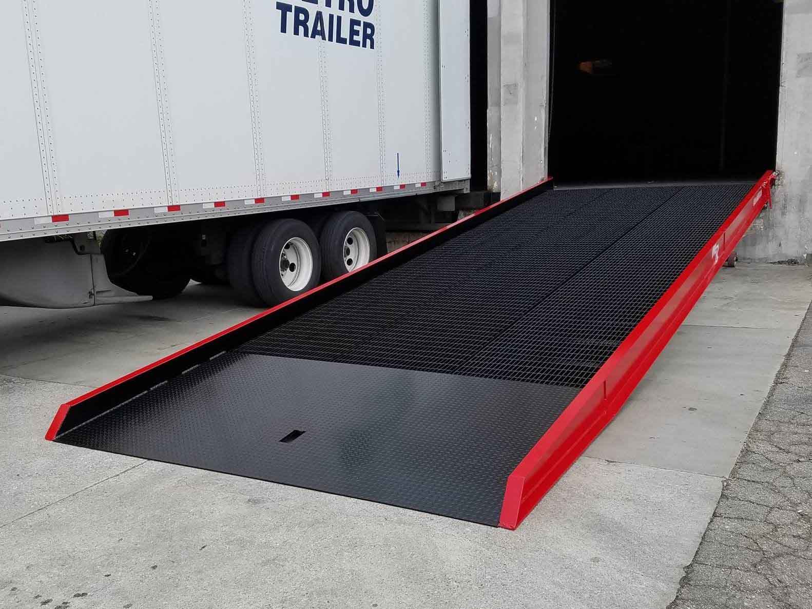 A Medlin Ramp leaning against a loading dock next to a semi-truck.