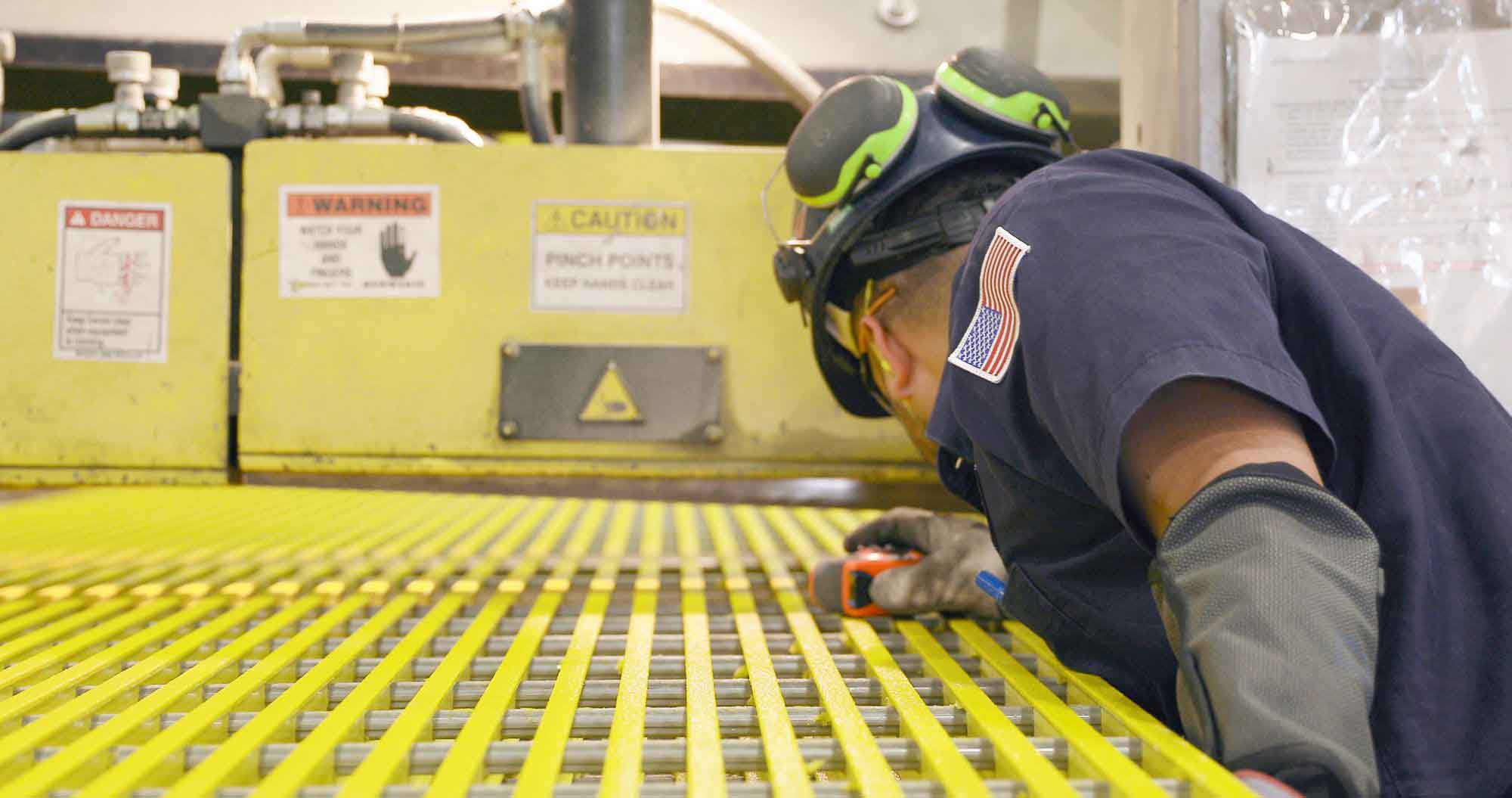 A McNICHOLS Associate positioning Fiberglass Grating before turning on the saw.