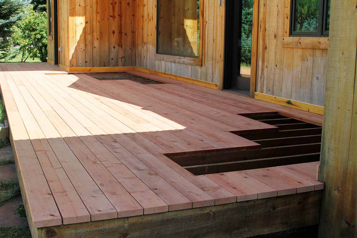 A wooden deck with areas cut out for Bar Grating drains.