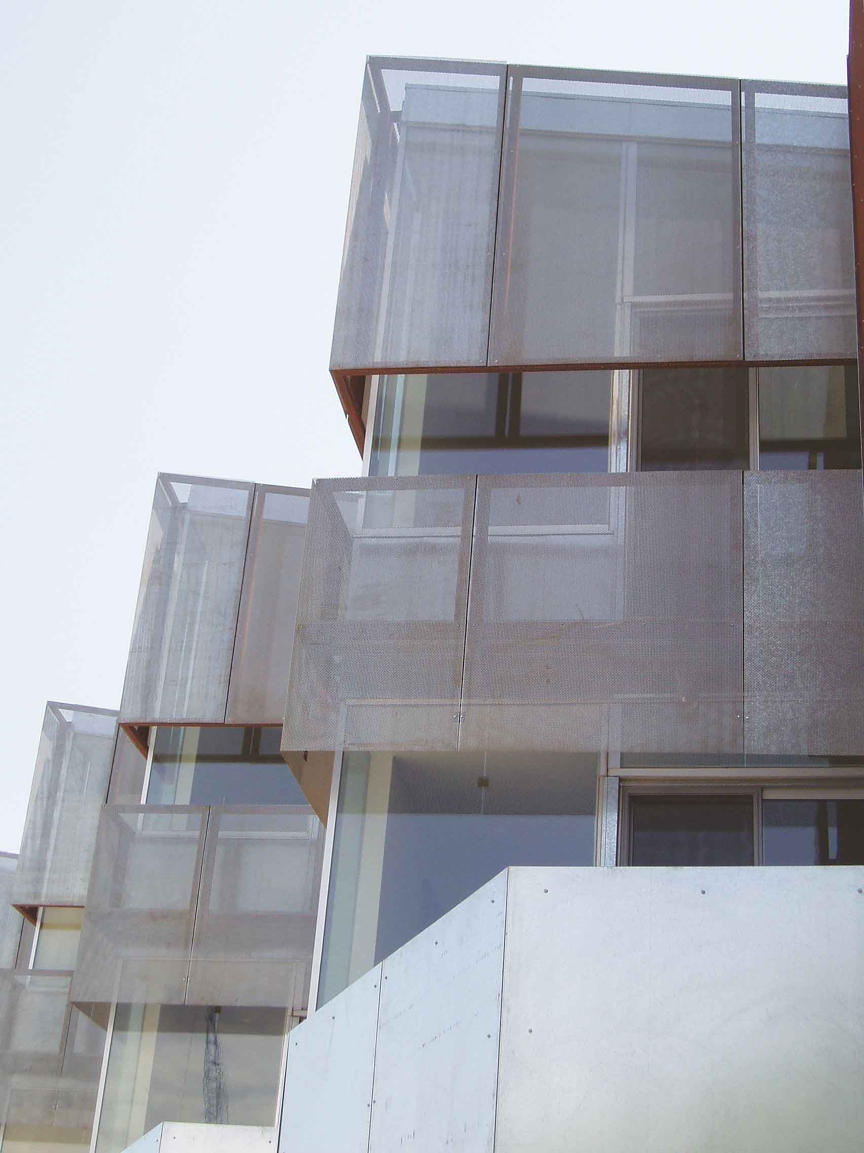 Perforated Metal panels used as sunshades and security on a glass town home.