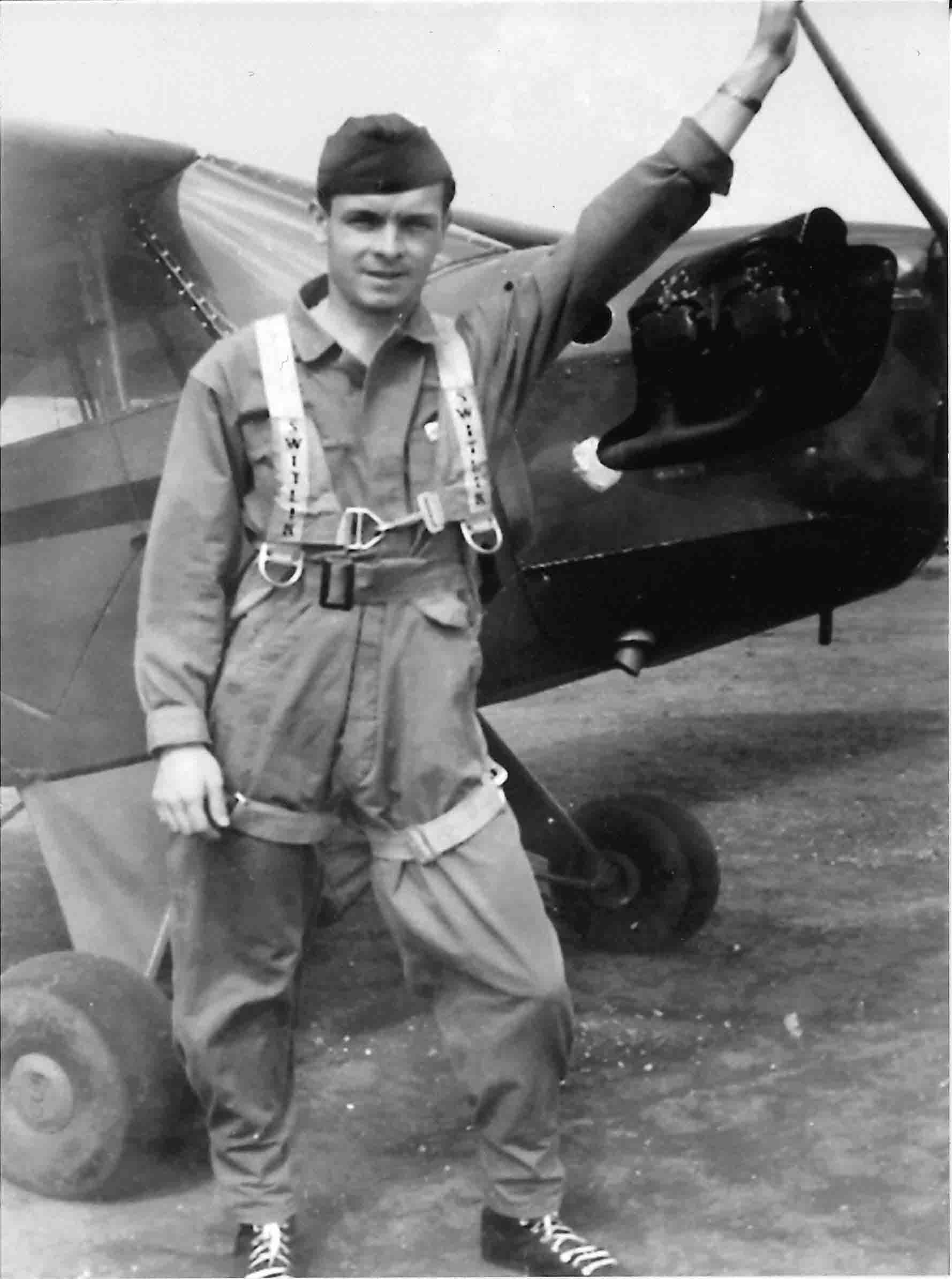 Bob McNichols standing next to a plane while wearing his US Army Air Corps uniform.
