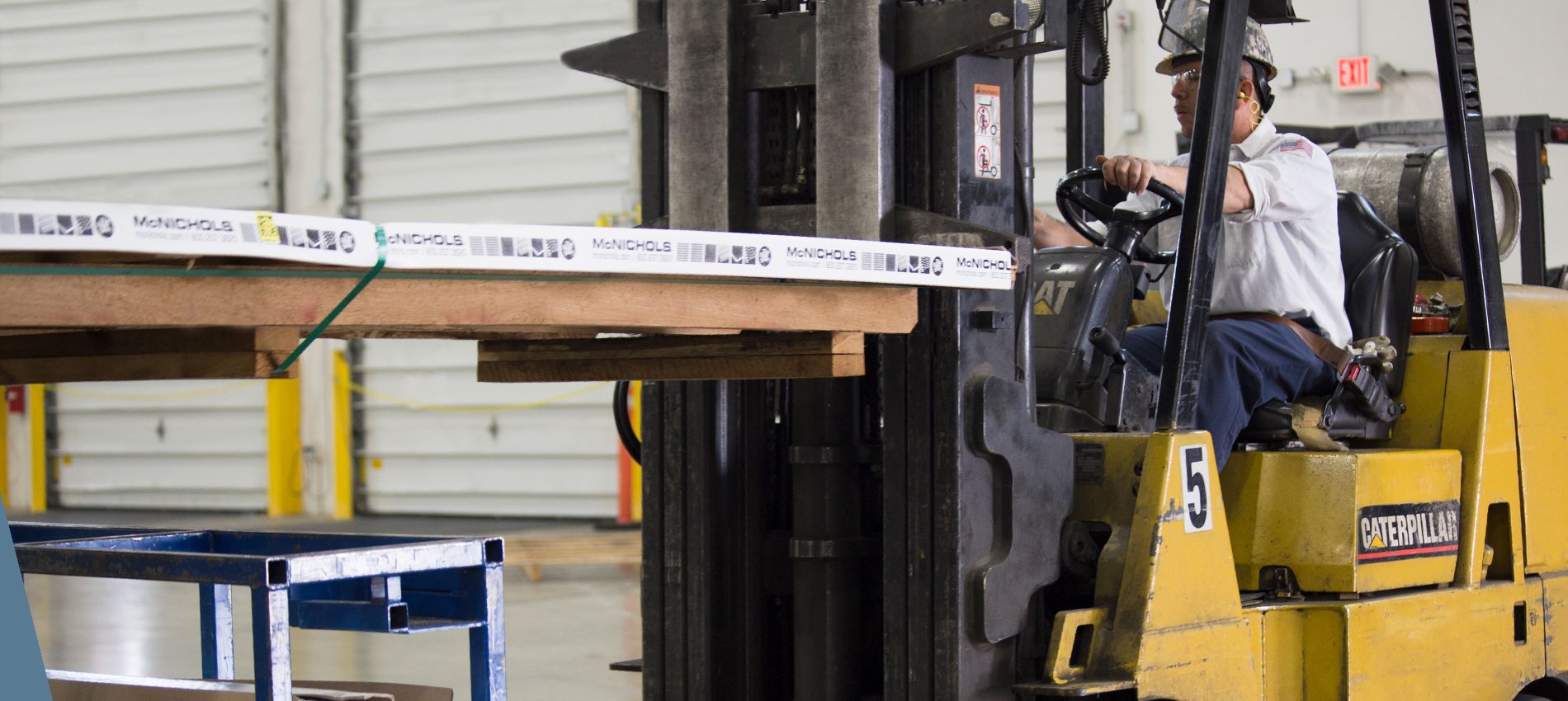 An operations associate operating a forklift to move a package.