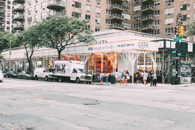 A street in NYC with scaffolding over the sidewalk.