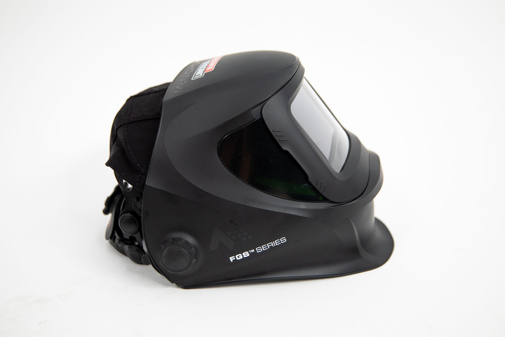 Side view of a sleek McNICHOLS branded welding helmet, featuring adjustable straps and a tinted visor, displayed as the prize in a giveaway.