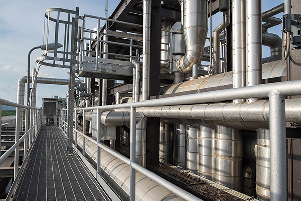 A picture of a walkway around a boiler building in a power plant.