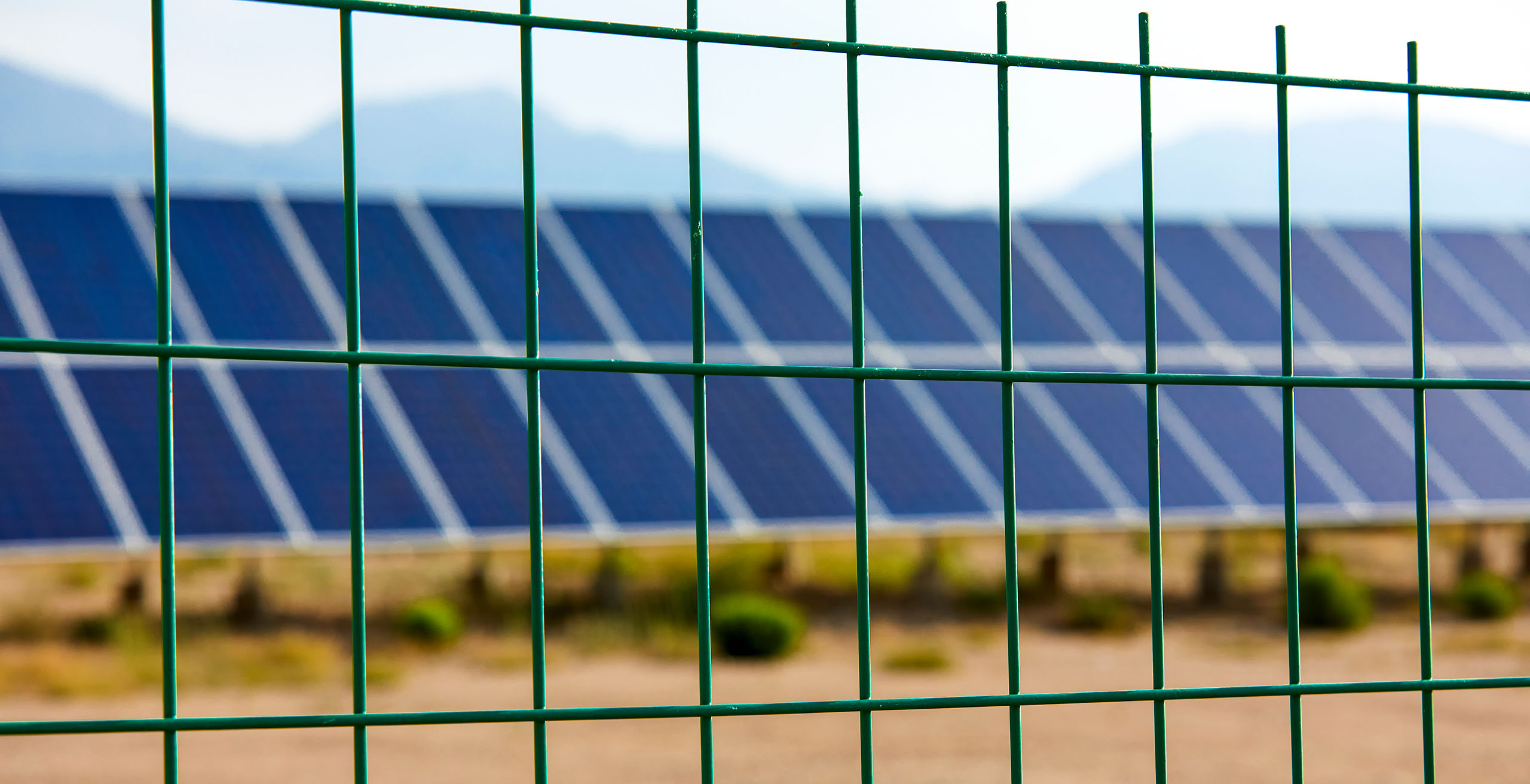 A hero image showing a close up of Wire Mesh with solar panels in the background.
