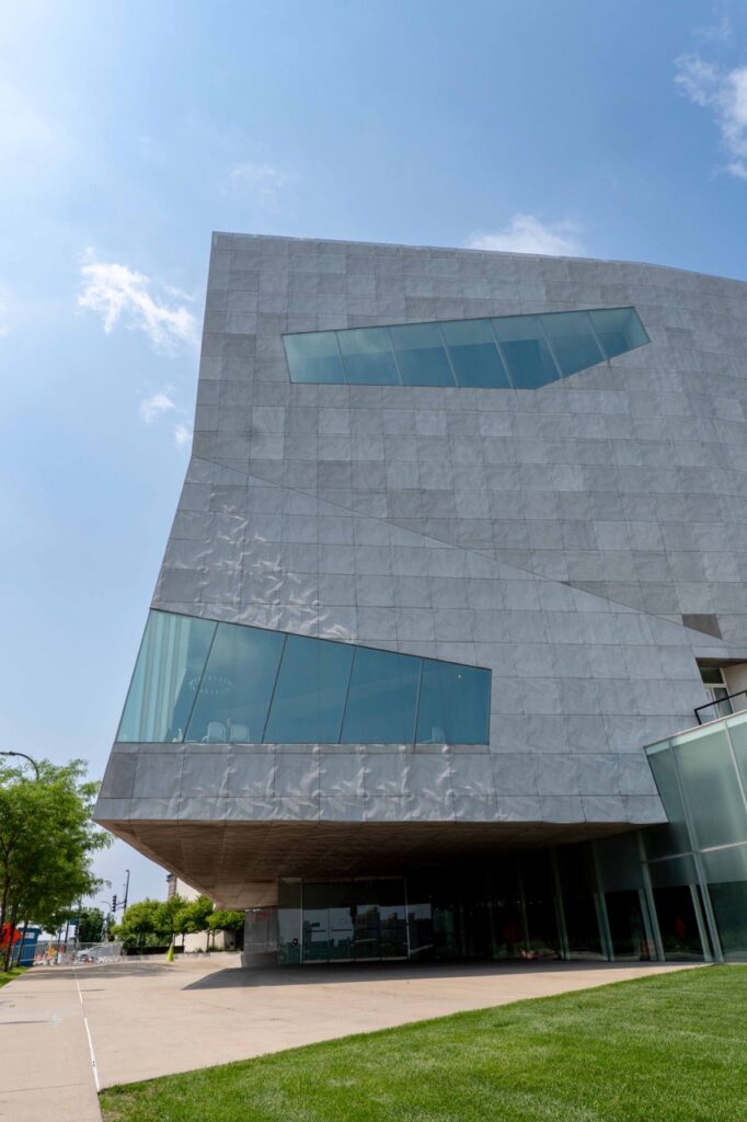 Angled exterior view of the Walker Art Center in Minneapolis, MN, showcasing Designer Expanded Metal, Flattened LANCET™ 31651-F facade with geometric windows and textured panels above a pedestrian walkway and lawn.