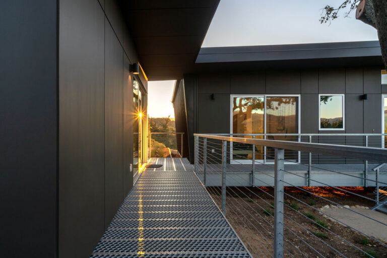Side walkway view of residence with 6-Hole PERF-O GRIP® Plank Grating flooring and metal railing system.