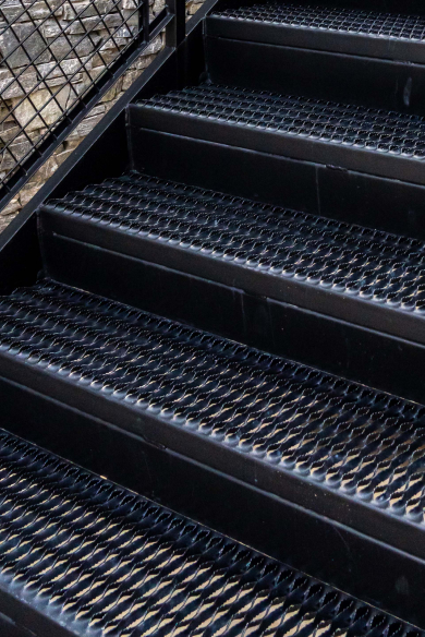 Plank Grating Stair Treads that are powder-coated black.