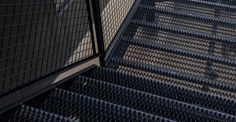 Powder-Coated Black GRIP STRUT® Plank Grating Stair Treads in a residential building.