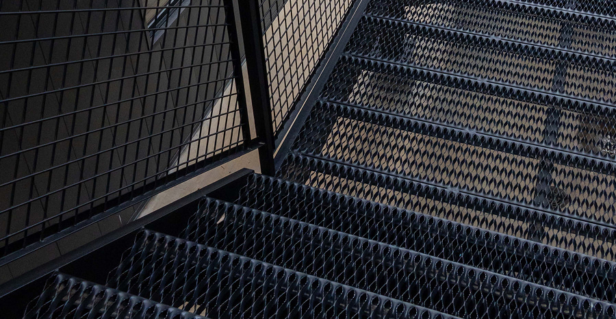 Powder-Coated Black GRIP STRUT® Plank Grating Stair Treads in a residential building.