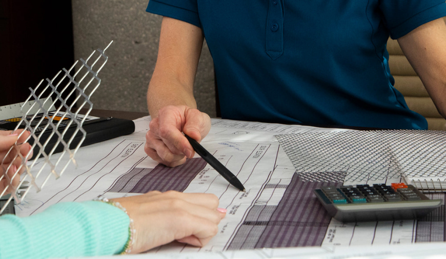 Image of a McNICHOLS associate reviewing blueprint drawings.
