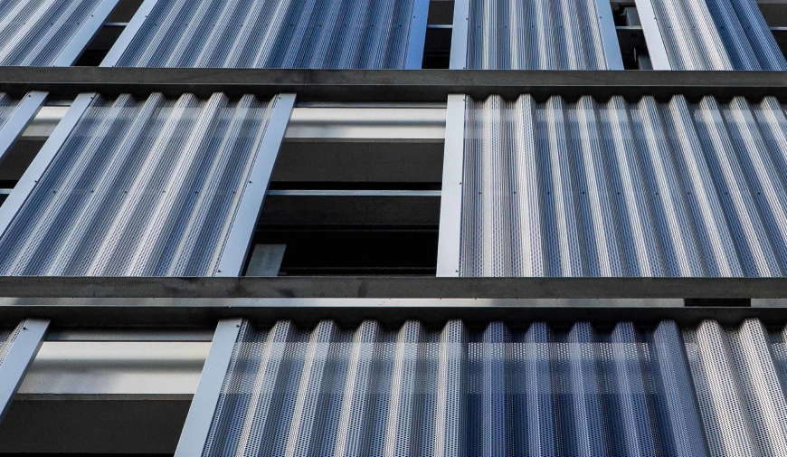 Corrugated Perforated Metal sheets used as partitions on the side of a garage.