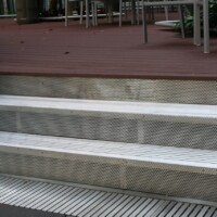 Aluminum Swage-Locked T-Bar Bar Grating used for Stair Treads and a trench drain at an outdoor patio entrance.