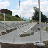 Wide view of a Cleveland pedestrian tunnel ramp with curved railings and Square Wire Mesh sheets with an Intercrimp Weave and framed with U-Edging mounted along sloped concrete retaining walls.