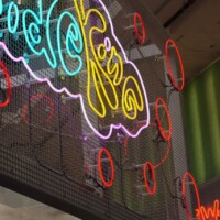 Colorful neon sign mounted on Square Wire Mesh sheet that is Welded and Stainless Steel at POST Market Houston.
