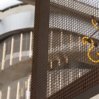 Interior architectural detail featuring Square Wire Mesh sheet that is Welded and Stainless Steel with illuminated signage at POST Market Houston.