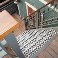 Residential stair system featuring 5-Hole PERF-O GRIP® Plank Grating stair treads.