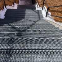 Snow-covered stairway featuring 5-Diamond GRIP STRUT® Plank Grating used as stair treads.