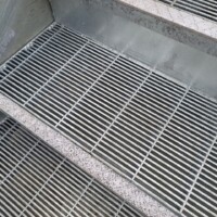Press-Locked Bar Grating Stair Treads installed on a concrete staircase with close-set rectangular bars.
