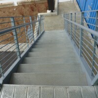 Staircase at The Box Office building featuring TRACTION TREAD™ Plank Grating stair treads with metal railing system.