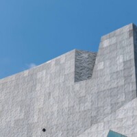 Wide view of Designer Expanded Metal, Flattened LANCET™ 31651-F facade at Walker Art Center in Minneapolis, MN, showing the angular building form and textured surface against a clear blue sky.