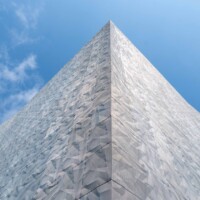 Angular exterior facade clad with Designer Expanded Metal, Flattened LANCET™ 31651-F at Walker Art Center in Minneapolis, MN, showcasing a faceted, light-reflective surface against the sky.