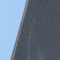 Close-up of Designer Expanded Metal, Flattened LANCET™ 31651-F at Walker Art Center in Minneapolis, MN, showing the fine perforation pattern and curved building edge against a blue sky.