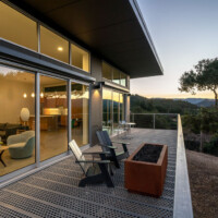 Residential exterior deck featuring 6-Hole PERF-O GRIP® Plank Grating flooring with outdoor seating and glass doors.